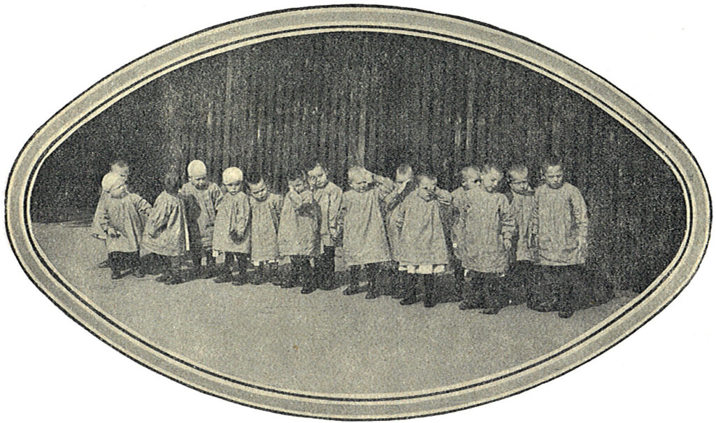 Kinderen van Hulp voor Onbehuisden bij de schutting in 1920