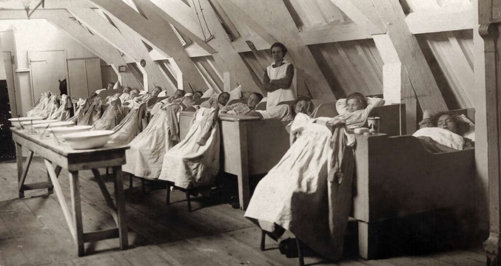 Zieken in bedden en ligstoelen op zolder in het Oud Buitengasthuis van HvO, 1925, foto uit Het Leven