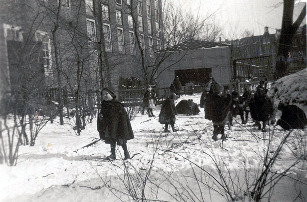 Kinderen in de sneeuw bij het Oud Buitengasthuis van Hulp voor Onbehuisden, 1933