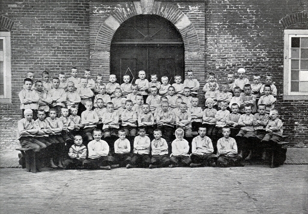Jongens poseren op de binnenplaats van het Oud Buitengasthuis van Hulp voor Onbehuisden in 1909