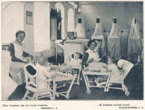 Kleine kinderen en zusters op zaal, foto uit het HvO-blad van 1927 met bijbelteksten als bijschrift