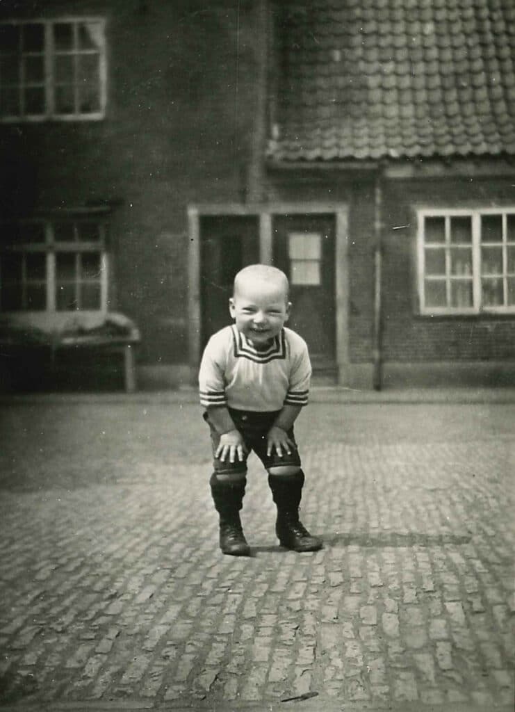 Daan, een jonge bewoner van Hulp voor Onbehuisden, op de binnenplaats van het Oude Buitengasthuis, 1929