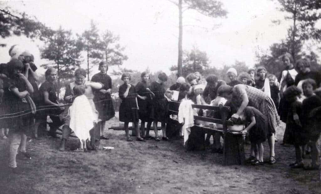 Vakantiekamp van Hulp voor Onbehuisden in Nunspeet in 1931, zuster Ossewaarde knipt het haar van een kind