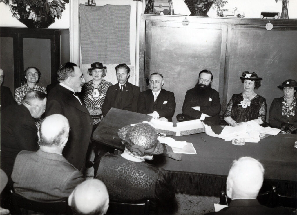 Bestuursvoorzitter Mendes da Costa (staand) spreekt directeur Honing toe, 1938