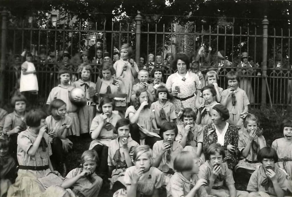 Meisjes van Hulp voor Onbehuisden eten buiten een boterham, jaren ’30