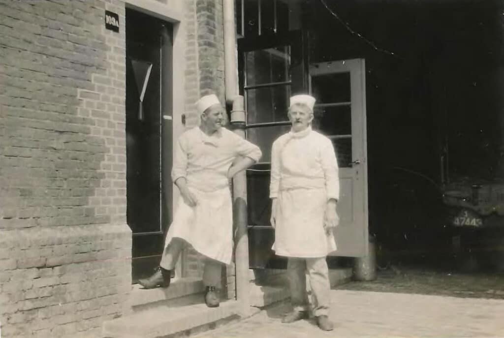 Koks bij Hulp voor Onbehuisden aan de Weesperzijde in de jaren '30. Op de achtergrond is een van de auto's te zien waarmee oud papier en dergelijke wordt opgehaald.