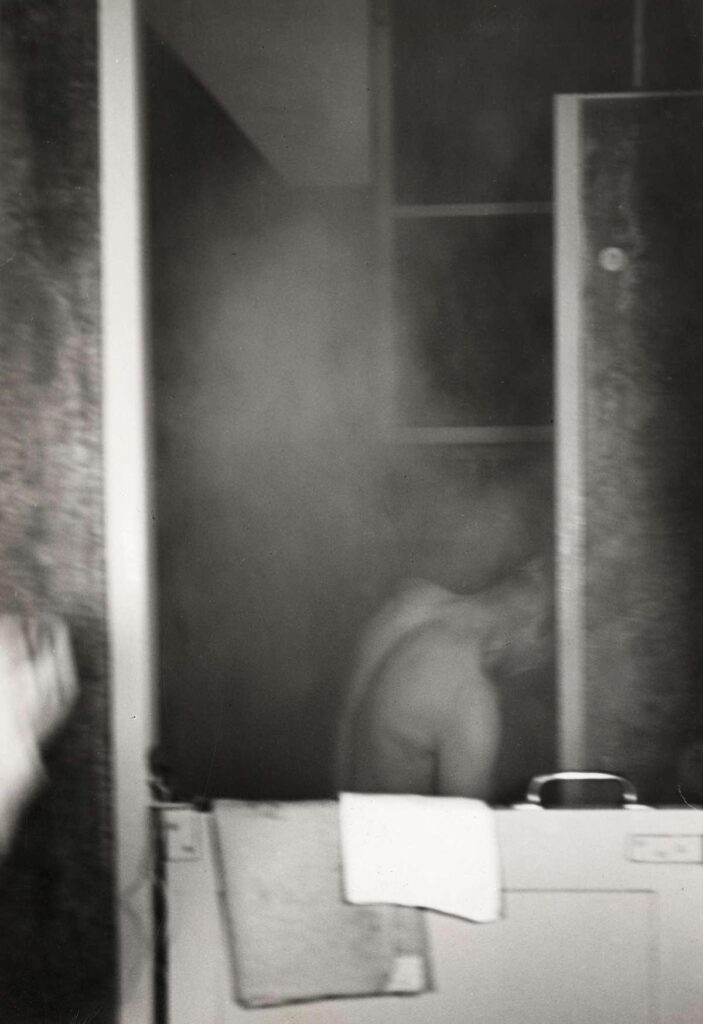 Nachtasiel van vereniging voor onbehuisden Amsterdam. Man is zich aan het douchen in het asiel. De stoomwolken slaan ervan af. Foto uit Het Leven, 1939