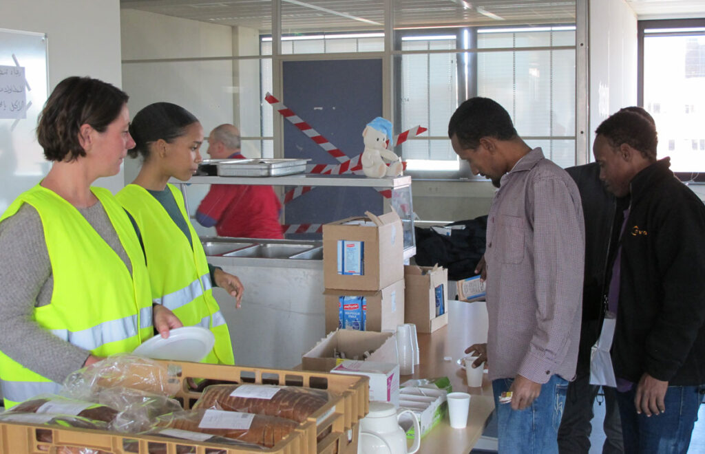 Bonne Klijnsma (links) helpt met een collega bij het verstrekken van de lunch aan vluchtelingen op de Flierbosdreef