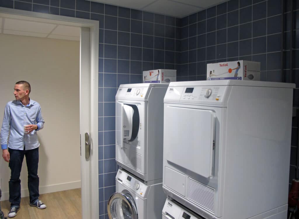 Ron laat de ruimte met wasmachines zien aan de Wilhelminastraat