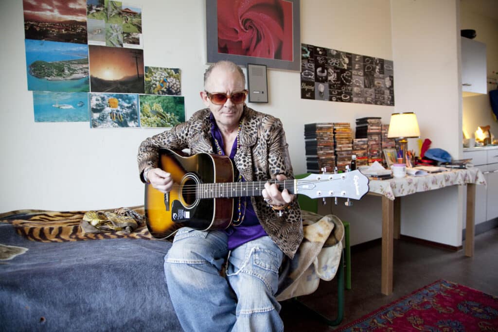 Jan Heupink speelt gitaar op zijn kamer in De Rijswijk