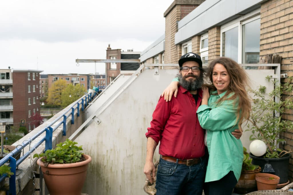 Tim en Jessica op het balkon van zijn woning in Amsterdam West. 
